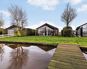 Buitenkant van Vakantiehuisje in Gaastmeer met groene tuin en waterkant.