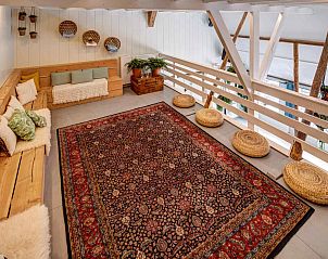 Knusse zithoek in vakantiehuis FR555, Nijhuizum, met kussens en decoratieve manden.