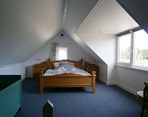 Ruime zolderkamer met houten bed in vakantiehuis Mts. J. en A. Faber-Breeuwsma, Wyckel, nabij het Slotermeer.