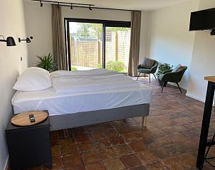 Ruime kamer met zithoek in Bed & Breakfast Zeeland, Noordwelle, met uitzicht op de tuin.