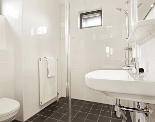 Gezellige eettafel in Waterpark Sneekermeer 4-persoons woning 4C, Terherne, met fruit en glazen voor een huiselijke sfeer.