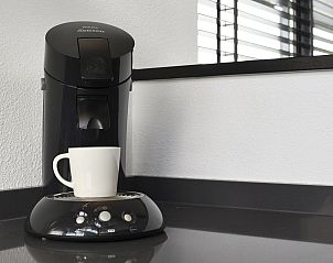 Onderste terras van Waterpark Sneekermeer 4-persoons woning 4C, Terherne, met zitmogelijkheden en uitzicht op de tuin.