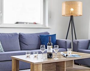 Woonkamer met wijn en glazen in Waterpark Sneekermeer 8-persoons woning, Terherne.