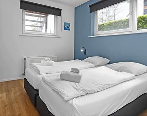 Slaapkamer met blauwe accenten in Waterpark Sneekermeer vakantiehuis, Terherne.