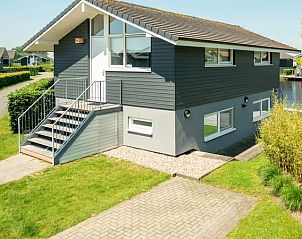 Buitenkant van Waterpark Sneekermeer 6-persoons woning 6C2 in Terherne, omringd door groen.