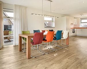 Lichte eetruimte in Waterpark Terherne, 8-persoons waterwoning, Terherne, Sneekermeer, met kleurrijke stoelen.