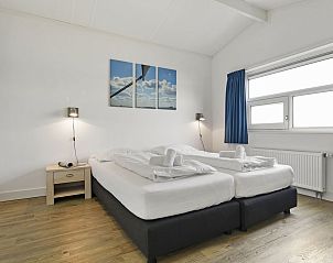 Slaapkamer met kunst aan de muur in bungalow 4C, Terherne, Friese meren.