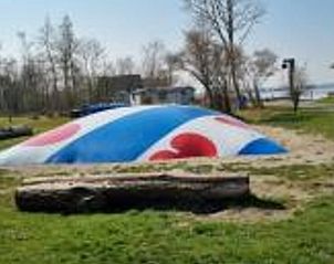 Grote trampoline bij Vakantiehuisje in Offingawier, familievriendelijke vakantiewoning aan Sneekermeer.