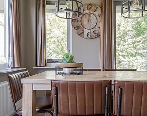 Gezellige eetkamer in Vakantiewoning de Tjalk, Offingawier, met houten tafel en moderne stoelen nabij Sneekermeer, Friese meren.