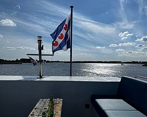 Uitzicht vanaf het dakterras van Vakantiehuis in Offingawier op het Sneekermeer met Friese vlag.