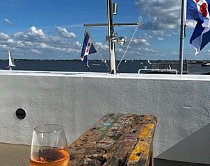 Genieten van een drankje op het dakterras van Vakantiehuis in Offingawier aan het Sneekermeer.