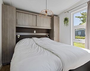 Hoofdslaapkamer van Chalet de Tjotter in Offingawier, biedt comfort en uitzicht op de groene omgeving.