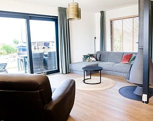 Gezellige woonkamer in Huisje in Akkrum, vakantiehuis aan het Sneekermeer, Friese meren, met uitzicht op het terras.