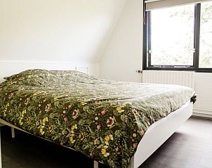 Sfeervolle slaapkamer in Huisje in Akkrum, vakantiehuis aan het Sneekermeer, Friese meren, met comfortabel bed.