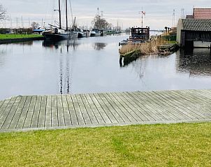 Natuurlijke omgeving bij Huisje in Akkrum, vakantiehuis aan het Sneekermeer, Friese meren, met water en groen.