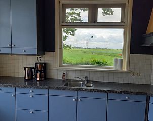 Uitzicht op groene velden vanuit keukenraam van Vakantiehuisje in Akkrum, vakantiewoning bij Sneekermeer, Friese meren.