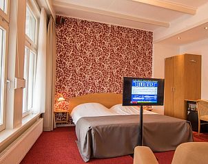 Comfortabele slaapkamer in Die Port van Cleve vakantiehuis, Enkhuizen, met uitzicht op de IJsselmeerkust.