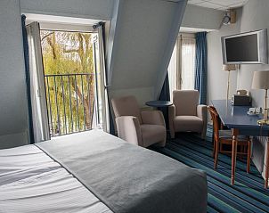 Stijlvolle kamer in Die Port van Cleve vakantiehuis, Enkhuizen, met balkon en uitzicht op de IJsselmeerkust.