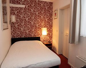 Intieme tweepersoonskamer in Die Port van Cleve vakantiehuis, Enkhuizen, met sfeervolle verlichting aan de IJsselmeerkust.