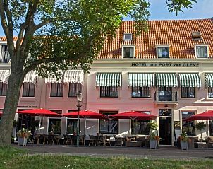 Slaapkamer in Die Port van Cleve vakantiehuis, Enkhuizen, met grote ramen en veel natuurlijk licht aan de IJsselmeerkust.