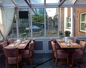 Lichte serre met eetruimte in SuyderSee Hotel, vakantieappartement in Enkhuizen, Noord-Holland.