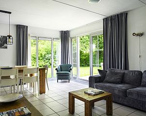 Gezellige woonkamer in Vakantiehuis Bungalowpark It Wiid, Earnewld, met uitzicht op tuin.