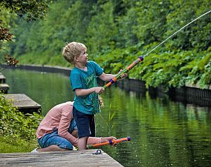 Kinderen vissen bij Vakantiehuis Bungalowpark It Wiid, Earnewld, omgeven door natuur.