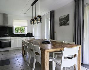 Moderne eetruimte in Vakantiehuis Bungalowpark It Wiid, Earnewld, met houten tafel en stoelen.