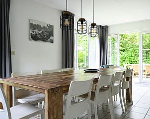 Lichte eetkamer in Vakantiehuis Bungalowpark It Wiid, Earnewld, met uitzicht op groene omgeving.