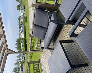 Geniet van de veranda bij Vakantiehuis Natuurlijk de Veenhoop in De Veenhoop, met uitzicht op de groene omgeving van de Friese meren.