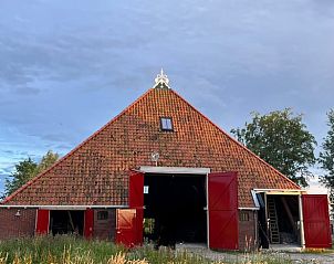 Authentieke boerderij bij Vakantiehuis in Grou, Grouw, met rode deuren en groene omgeving, nabij Pikmeer.