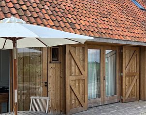 Zonnig terras bij Vakantiehuis in Grou, Grouw, met parasol en houten meubels, Friese meren.