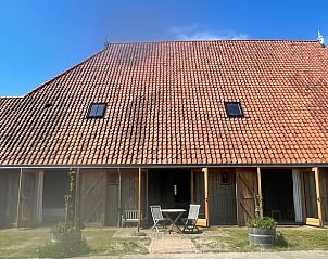 Buitenkant van Vakantiehuis in Grou, Grouw, met rode dakpannen en houten terras, nabij Pikmeer.