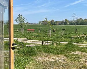 Uitzicht vanuit Vakantiehuis in Grou, Grouw, op groene velden en bankje, Friese meren.