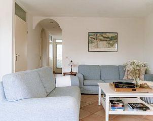 Ruime woonkamer in Vakantiehuis in Grouw met comfortabele banken en decoratie.