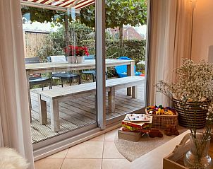 Gezellig terras met picknicktafel bij Vakantiehuis in Grouw, omgeven door groen.