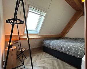 Knusse slaapkamer in Huisje in Gongahuizen, vakantiehuis in Pikmeer, Friese meren, met dakraam en houten details.