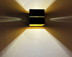 Moderne wandlamp in Huisje in Gongahuizen, vakantiehuis in Pikmeer, Friese meren, zorgt voor sfeervolle verlichting.