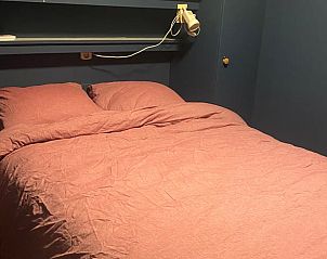 Sfeervolle slaapkamer met tweepersoonsbed in Vakantiehuisje in Aldeboarn, rustgevende plek aan de Friese meren.