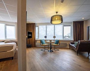 Ruime suite met zitgedeelte in Fletcher Hotel-Restaurant Arneville-Middelburg, vakantieaccommodatie in Middelburg, Zeeland.