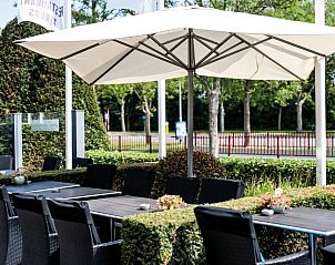 Buitenterras met parasols bij Fletcher Hotel-Restaurant Arneville-Middelburg, gelegen in Middelburg, Zeeland.