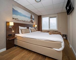 Slaapkamer met tweepersoonsbed in Fletcher Hotel-Restaurant Arneville-Middelburg, vakantieappartement in Middelburg, Walcheren.