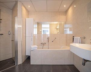 Luxe badkamer met bad en douche in Fletcher Hotel-Restaurant Arneville-Middelburg, vakantieaccommodatie in Middelburg, Zeeland.