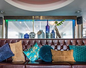 Stijlvolle lounge met kussens in Fletcher Hotel-Restaurant Arneville-Middelburg, gelegen in Middelburg, Zeeland.