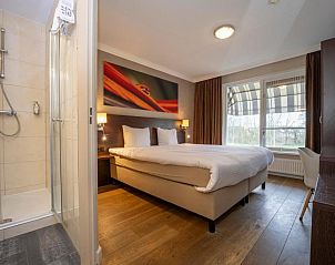 Slaapkamer met ensuite badkamer in Fletcher Hotel-Restaurant Arneville-Middelburg, vakantieaccommodatie in Middelburg, Zeeland.