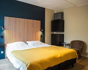 Slaapkamer met houten accenten in Hotel De Horper Wielen, vakantieappartement op Terschelling.