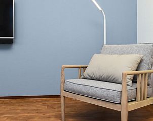 Comfortabele fauteuil in de woonkamer van Esonstad 6-persoons maisonnette, Anjum, perfect voor rust.