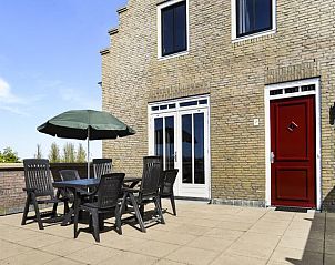 Zonnig terras van Esonstad vakantiehuis in Anjum, met zitgelegenheid en uitzicht op de natuur.