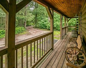 Houten veranda bij Bungalow Diever - Countryhouse Moshannon in Diever, Zuidwest Drenthe, met uitzicht op bosrijke omgeving, perfect voor ontspanning.