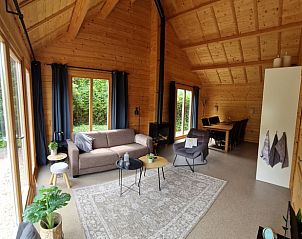 Gezellige binnenruimte van Huisje in Spier, vakantiehuis in Midden Drenthe, met houten interieur en comfortabele zithoek.
